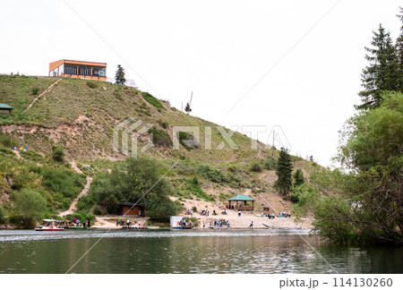 Scenic mountain lake with a building, trees, and crystal clear water Scenic mountain lake with a building, trees, and crystal clear water 114130260