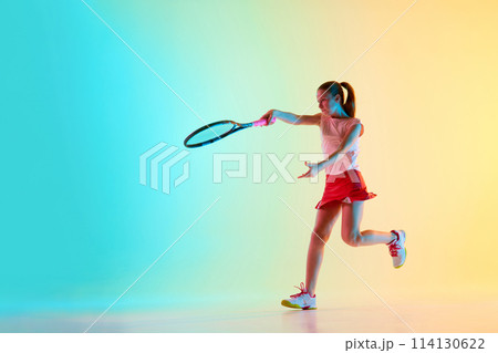 Competitive young girl, female athlete training passing shot in motion in neon light against blue-yellow background. 114130622