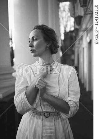 elegant middle age woman in white vintage dress near theater with antique colonnades elegant middle age woman in white vintage dress near theater with antique colonnades 114132310
