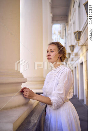 elegant middle age woman in white vintage dress near theater with antique colonnades elegant middle age woman in white vintage dress near theater with antique colonnades 114132317