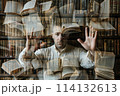 A man in the library shows his palms and a lot of books 114132613