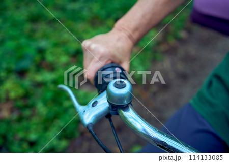 elderly woman walking in spring forest with bicycle and yoga mat 114133085