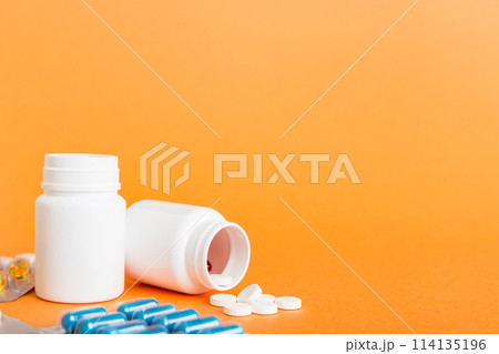 Medicine for treatment HIV infection. Pills and capsules and battle on the table. Different colorful tablets at colored background with copy space 114135196