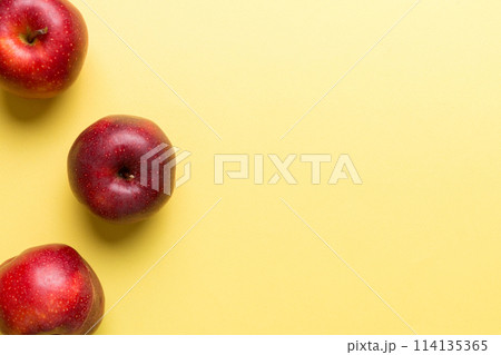 Many red apples on colored background, top view. Autumn pattern with fresh apple above view with copy space for design or text 114135365