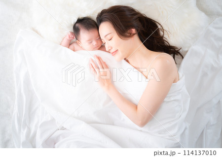 生後一ヶ月の息子と添い寝する母親 114137010