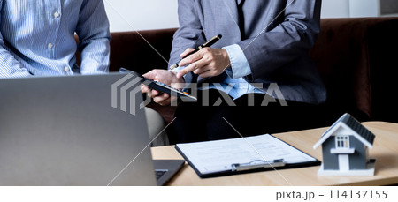 The real estate agent explains the business contract, rent, purchase, mortgage, a loan, or home insurance to the women buyer 114137155