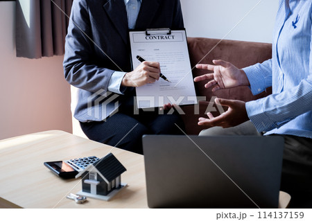 The real estate agent explains the business contract, rent, purchase, mortgage, a loan, or home insurance to the women buyer 114137159