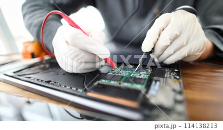 Technician soldering laptop parts Technician soldering laptop parts 114138213