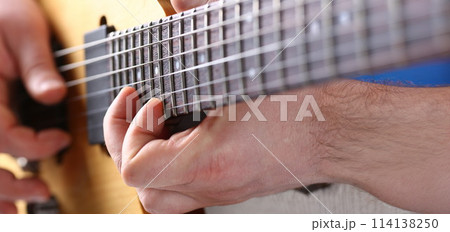 Male arms playing classic shape electric guitar 114138250