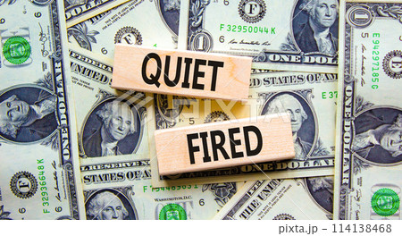 Quiet fired symbol. Concept words Quiet fired on wooden blocks. Beautiful background from dollar bills. Business and quiet fired concept. Copy space. Quiet fired symbol. Concept words Quiet fired on wooden blocks. Beautiful background from dollar bills. Business and quiet fired concept. Copy space. 114138468