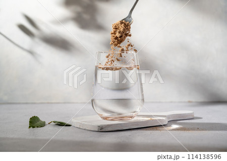 Protein collagen pink powder, fruits and vegetables powder, food supplement in a glass with water Protein collagen pink powder, fruits and vegetables powder, food supplement in a glass with water 114138596