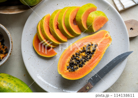 Papaya fruit closeup, sliced fresh papaya fruit with seeds Papaya fruit closeup, sliced fresh papaya fruit with seeds 114138611