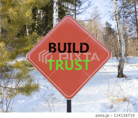 Build trust symbol. Concept words Build trust on beautiful red road sign. Beautiful forest snow blue sky background. Business and build trust concept, copy space. 114138719