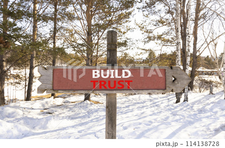 Build trust symbol. Concept words Build trust on beautiful wooden road sign. Beautiful forest snow blue sky background. Business and build trust concept, copy space. Build trust symbol. Concept words Build trust on beautiful wooden road sign. Beautiful forest snow blue sky background. Business and build trust concept, copy space. 114138728