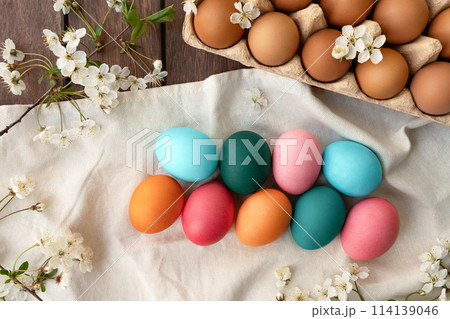Colorful Easter eggs and flowers displayed on a table 114139046