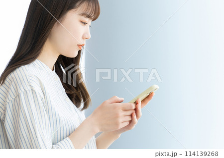 スマホを操作をするビジネスウーマンの横顔 スマホを操作をするビジネスウーマンの横顔 114139268