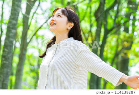緑の中で深呼吸をする若い女性 114139287