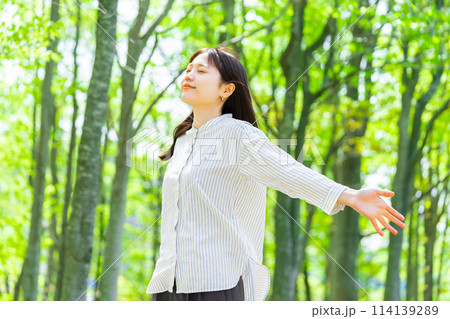 緑の中で深呼吸をする若い女性 114139289