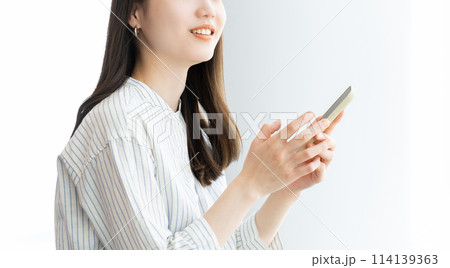 スマホを操作をする笑顔のビジネスウーマン スマホを操作をする笑顔のビジネスウーマン 114139363