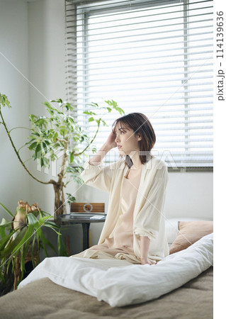 ベッドに腰掛ける20代女性 ベッドに腰掛ける20代女性 114139636