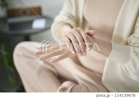 ベッドでハンドケアをする20代女性 114139676