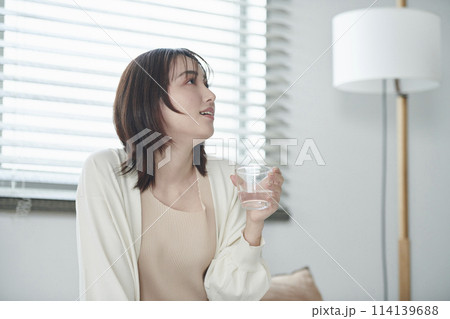 ベッドで水を飲む20代女性 114139688