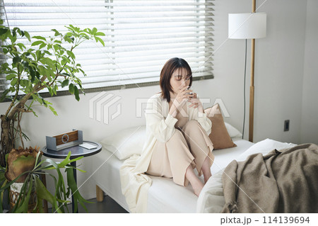 ベッドで水を飲む20代女性 ベッドで水を飲む20代女性 114139694