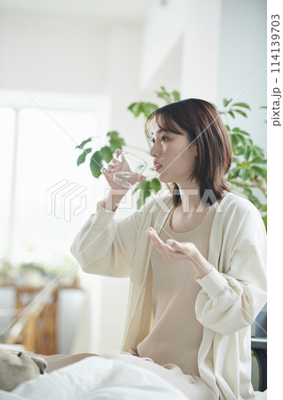 ベッドでサプリを飲む20代女性 ベッドでサプリを飲む20代女性 114139703