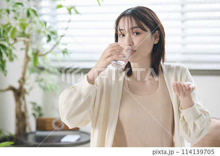 ベッドでサプリを飲む20代女性 ベッドでサプリを飲む20代女性 114139705
