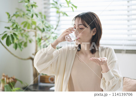 ベッドでサプリを飲む20代女性 ベッドでサプリを飲む20代女性 114139706