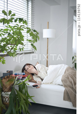目が覚めてあくびをする20代女性,朝 114139792