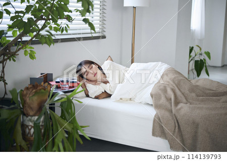 ベッドで眠る20代女性 114139793