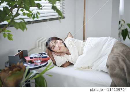 目を覚ました20代女性,朝 114139794