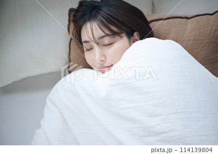 ベッドで眠る20代女性 114139804