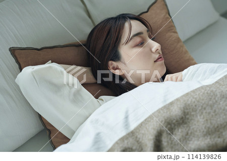 ベッドで横になる20代女性 114139826