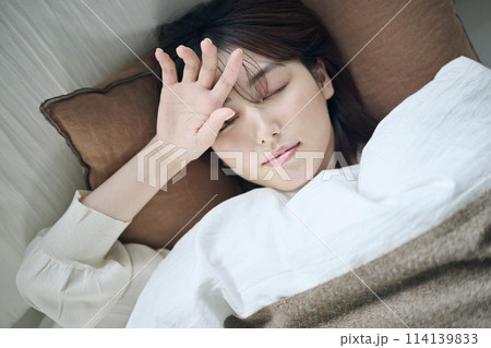 目を覚ました20代女性,朝 114139833