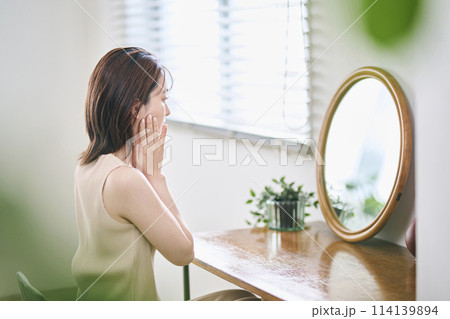 鏡の前でスキンケアをする20代女性 鏡の前でスキンケアをする20代女性 114139894
