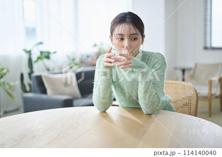 リビングで水を飲む20代女性 リビングで水を飲む20代女性 114140040