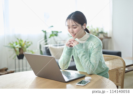 リビングでオンラインミーティングをする20代女性 リビングでオンラインミーティングをする20代女性 114140058