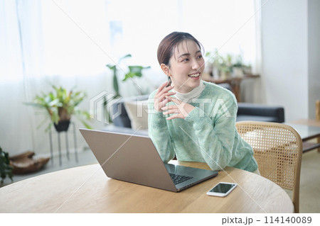パソコンでの作業中に談笑する20代女性 114140089