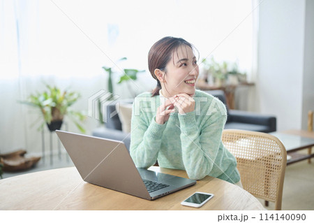 パソコンでの作業中に談笑する20代女性 パソコンでの作業中に談笑する20代女性 114140090