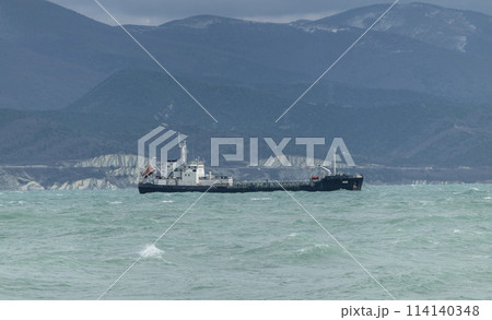 Sea freighter sailing in the middle of the ocean with big waves. Sea freighter sailing in the middle of the ocean with big waves. 114140348