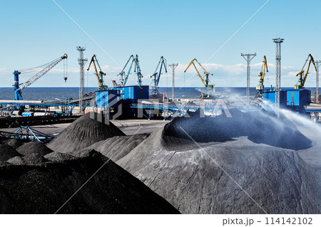 Spraying coal stockpiles with water with stockyard sprinkling system or water cannons on maritime bulk terminal. 114142102