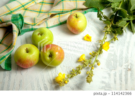 Several green apples on white wooden background.. 114142366