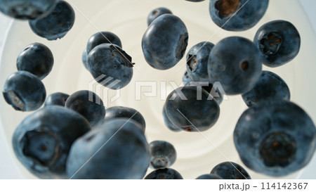 Fresh blueberries falling into yoghurt cream, top down view 114142367