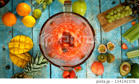 Freeze motion of mixing pieces of fruit and vegetables in blender, top shot 114142376