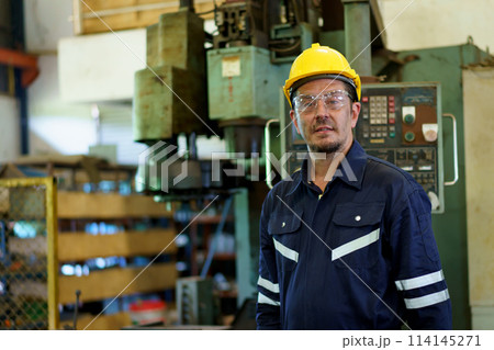 Smart and good looking senior factory or mechanical engineer standing in the factory portrait, caucasian white male engineer or foreman portrait in factory. 114145271
