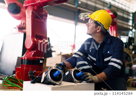 Professional caucasian white ethnicity male technician operating the heavy duty machine in the lathing factory. Technician in safety and helmet suit controlling a machine in factory. Professional caucasian white ethnicity male technician operating the heavy duty machine in the lathing factory. Technician in safety and helmet suit controlling a machine in factory. 114145284