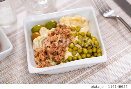 Russin salad with minced canned tuna, olives and pickled peas 114146625