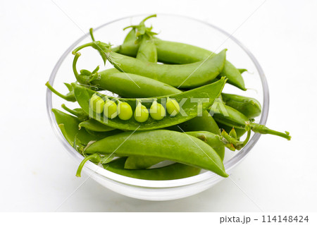 Fresh young green peas on white background. Fresh young green peas on white background. 114148424